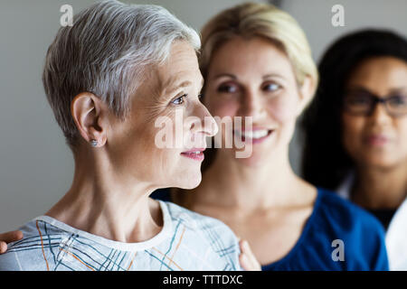 Thoughtful mature woman with daughter and doctor in background Stock Photo
