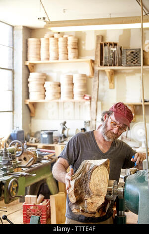 Carpenter using machinery in workshop Stock Photo