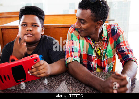 BERMUDA. St. George. Chef Marcus Samuelsson and AJ siting at a table at Art Mel's Spicy Dicy Restaurant. AJ is the son of Art Mel. Stock Photo