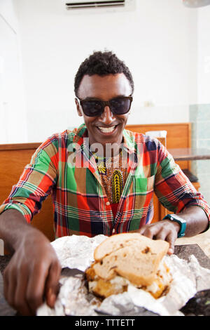 BERMUDA. St. George. Chef Marcus Samuelsson about to eat a fish sandwich at Art Mel's Spicy Dicy Restaurant in St. George. Stock Photo