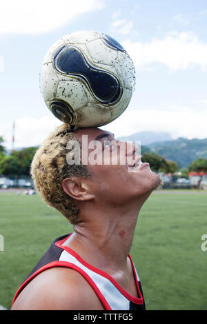FRENCH POLYNESIA, Tahiti, Papeete. A soccer game between locals at the Willy Bambridge Stadium. A young soccer player playing with the ball. Stock Photo