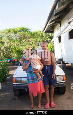 FRENCH POLYNESIA, Tahaa Island. Portrait of Grandfather and Grandmother with their Grandson in front of their home in Tahaa Island. Stock Photo
