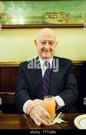 ITALY, Venice. A portrait of Harry's Bar owner, Arrigo Cipriani. He is holding a Bellini, a famous cocktail invented at Harry's Bar by Giuseppe Cipria Stock Photo