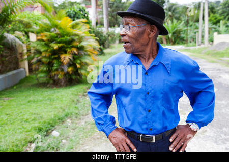 JAMAICA, Port Antonio. Joseph 'Powder' Bennett of the Mento band, The Jolly Boys standing in front of a vintage blue car. Stock Photo