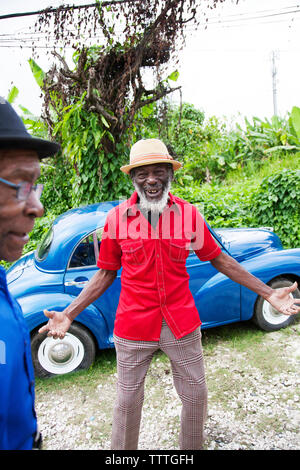 JAMAICA, Port Antonio. Joseph 'Powder' Bennett and Derrick 'Johnny' Henry of the Mento band, The Jolly Boys standing in front of a vintage blue car. Stock Photo