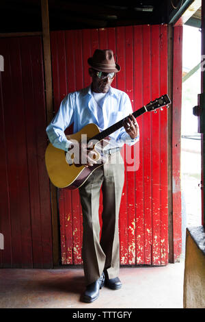 JAMAICA, Port Antonio. Albert Minott of the Mento band, The Jolly Boys playing guitar at the Willow Wind Bar. Stock Photo