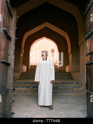 OMAN, man in traditional clothing standing in front of steps, portrait Stock Photo