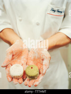 SINGAPORE, Ritz Carlton hotel, mid section of chef holding moon cakes. Stock Photo