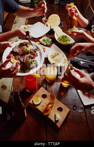 Cropped image of people having meal at table Stock Photo
