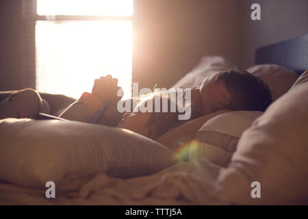 Parent and child share a lazy morning in beautiful, dreamy light. Stock Photo