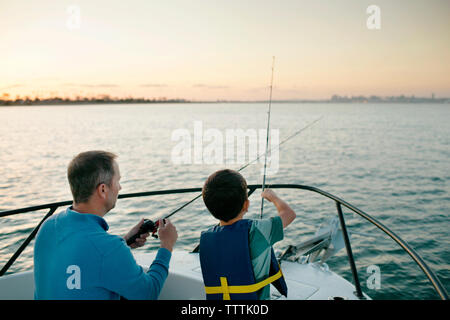 Father and son fishing on boat Stock Photo