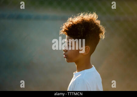 Side view of thoughtful boy at basketball court Stock Photo