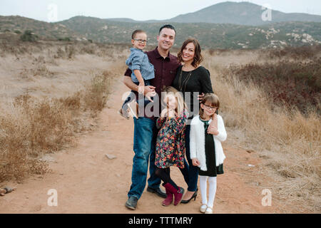 Portrait of happy family standing on field Stock Photo