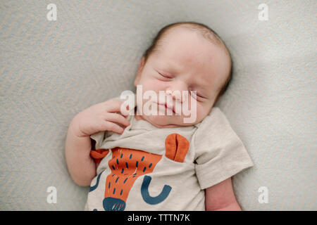 Overhead view of cute newborn baby boy sleeping on bed at home Stock Photo