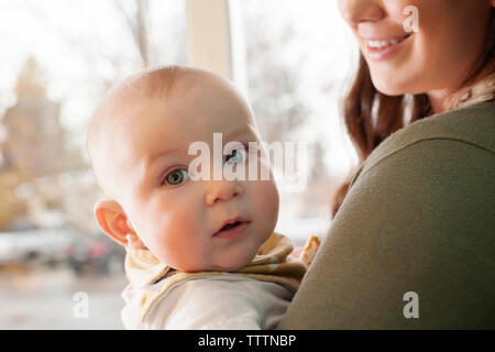 Midsection of mother holding baby at home Stock Photo