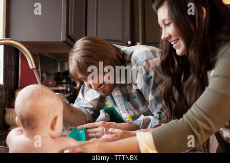 Happy parents bathing baby at home Stock Photo