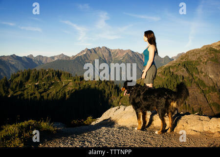 Side view of woman with dog on mountain Stock Photo