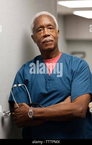 Portrait of doctor leaning on wall in hospital Stock Photo