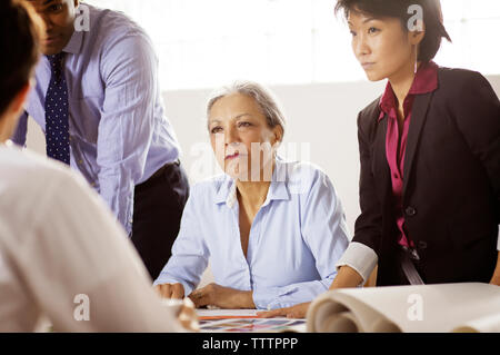 business people looking at colleague during meeting in office Stock Photo