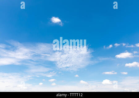 Deep blue sunny sky with white clouds. Blue sky with cloud closeup. White fluffy clouds in the blue sky. Stock Photo