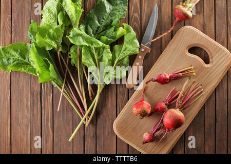 Fresh beets and knife on wooden board Stock Photo