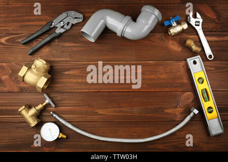 Plumber tools frame on wooden background Stock Photo