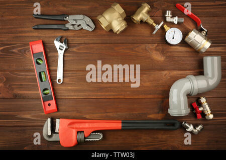 Plumber tools frame on wooden background Stock Photo