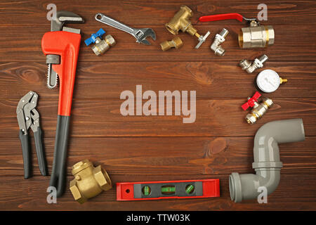 Plumber tools frame on wooden background Stock Photo