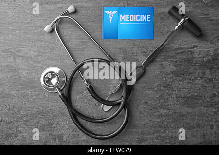 Medical concept. Stethoscope, hammer and business card on gray background Stock Photo