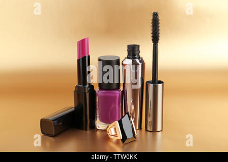 Decorative cosmetics and female accessory on blurred golden background Stock Photo