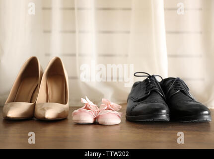 Family concept. Shoes for parents and child on floor in the room Stock Photo