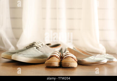 Family concept. Shoes for parents and child on floor in the room Stock Photo