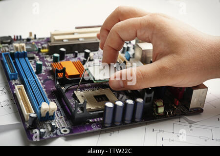Man installing microprocessor on motherboard, close up Stock Photo