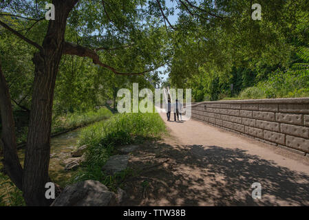 SEOUL, SOUTH KOREA - MAY 31, 2019: Three men are walking on a path near the Cheonggyecheon stream Stock Photo