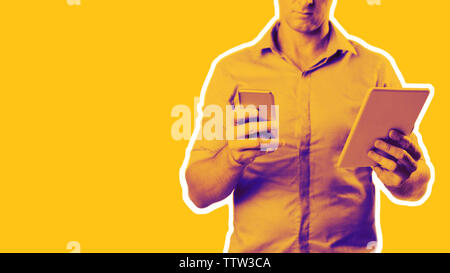 Man dressed casually in collared shirt using a tablet and phone -  Casual business concept image with copy space for text. Stock Photo