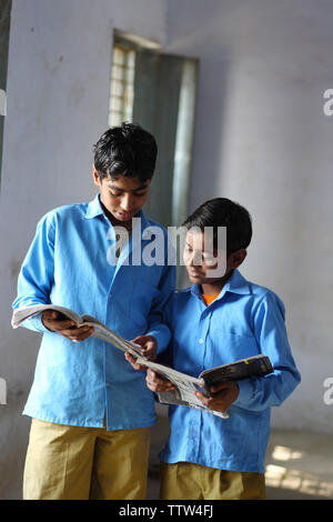 Two schoolboys reading books in a classroom Stock Photo