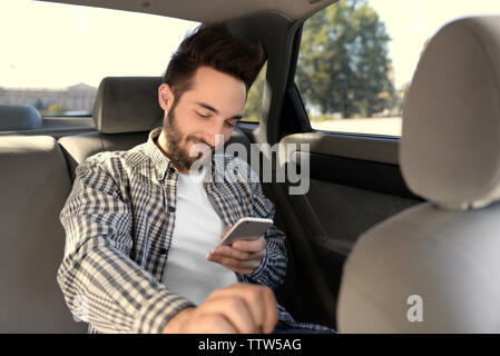 Successful young man using mobile phone while sitting in car Stock Photo