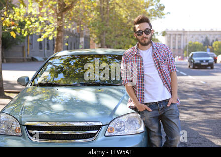 Successful young man standing near car Stock Photo