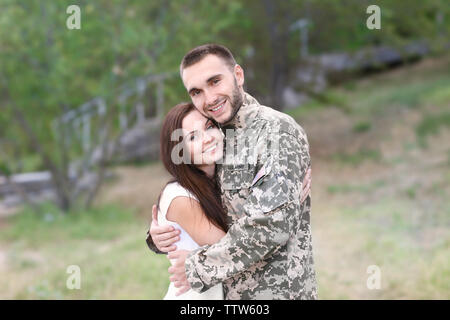 Happy US army soldier with wife in park Stock Photo