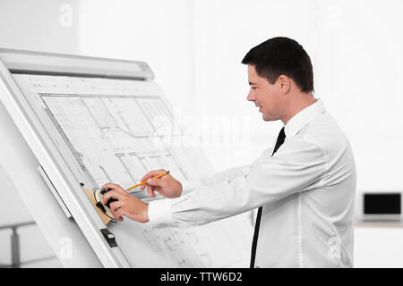 Young creative male engineer making project on drawing board Stock Photo