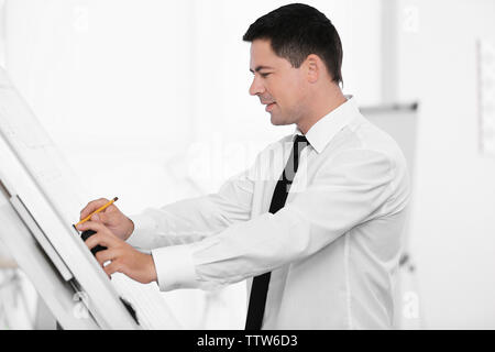 Young creative male engineer making project on drawing board Stock Photo