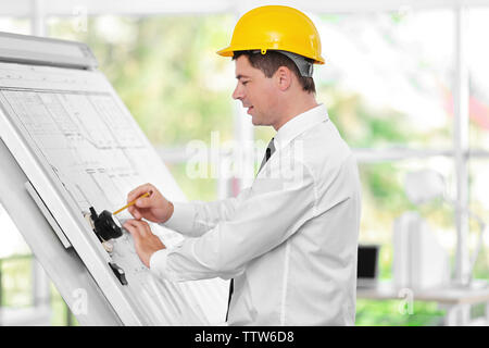 Young creative male engineer making project on drawing board Stock Photo