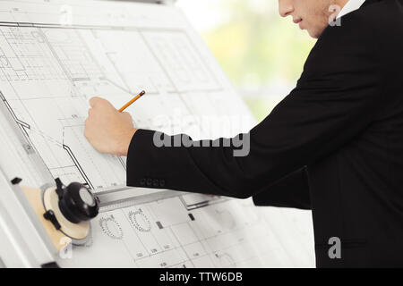 Young creative male engineer making project on drawing board Stock Photo