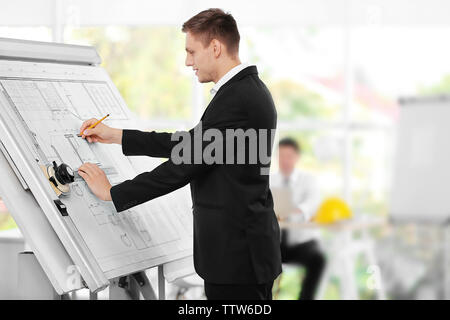 Young creative male engineer making project on drawing board Stock Photo