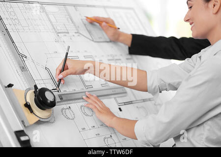 Two young creative engineers working with project on drawing board Stock Photo