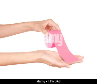 Female hands holding special physio tape roll on white background Stock Photo
