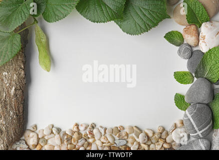 Frame made of pebbles, green leaves and bark Stock Photo