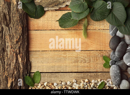 Rectangular frame made of leaves, pebbles and bark on wooden background Stock Photo