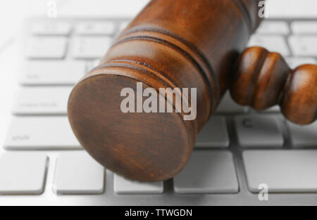 Wooden judge's gavel on computer keyboard, closeup Stock Photo