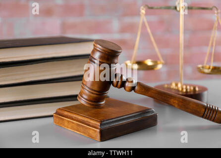 Gavel with books and scales on brick wall background Stock Photo